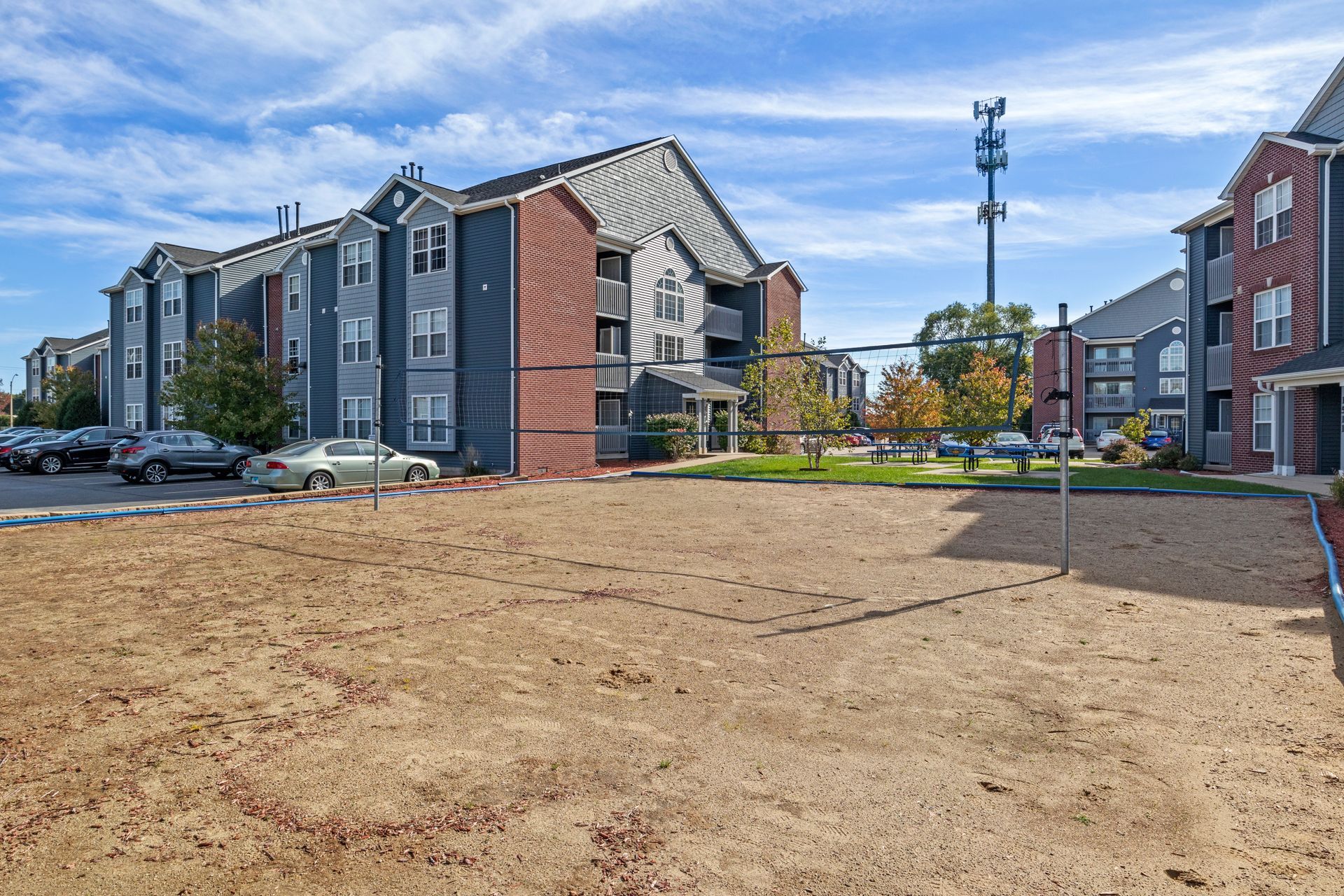 A volleyball court in front of a large apartment building.