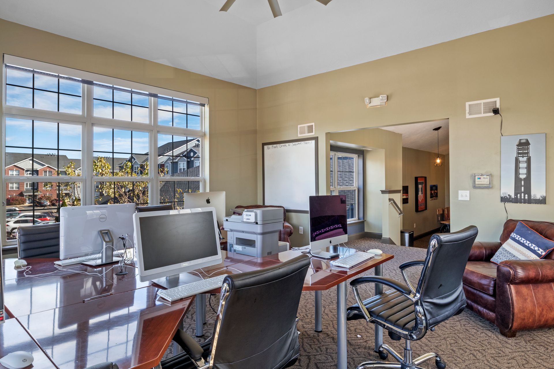 A room with a desk and chairs and a computer on it