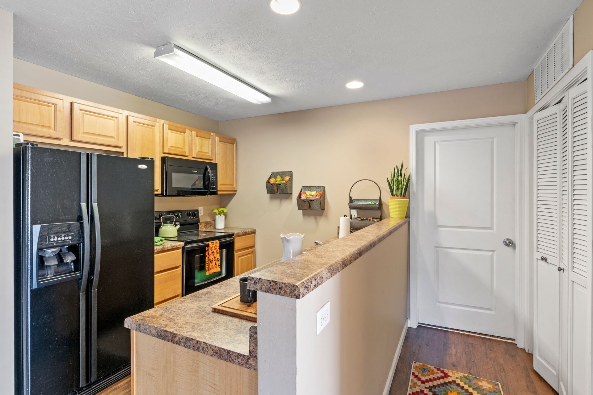 A kitchen with a refrigerator , stove , microwave and sink.