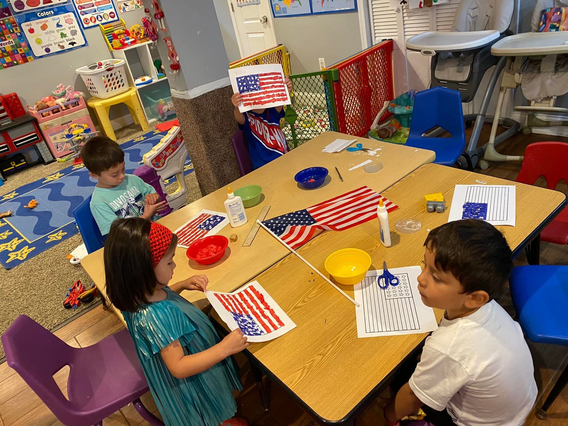 Children at a table doing art. They are making American flags.