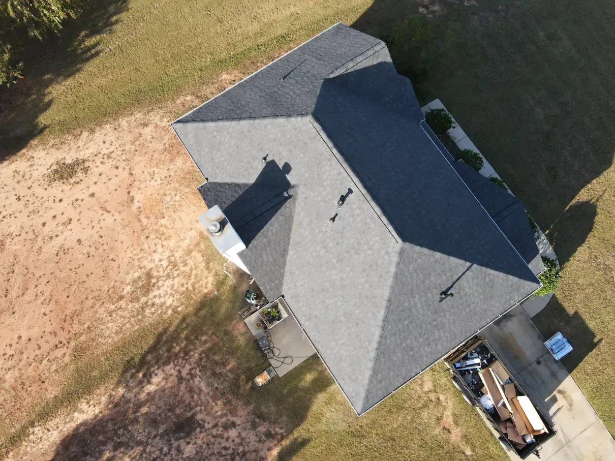 Two electricians working on an electrical panel outside a building. One holds a cable.