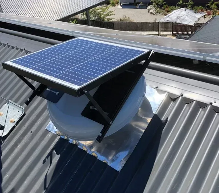 Two electricians working on an electrical panel outside a building. One holds a cable.