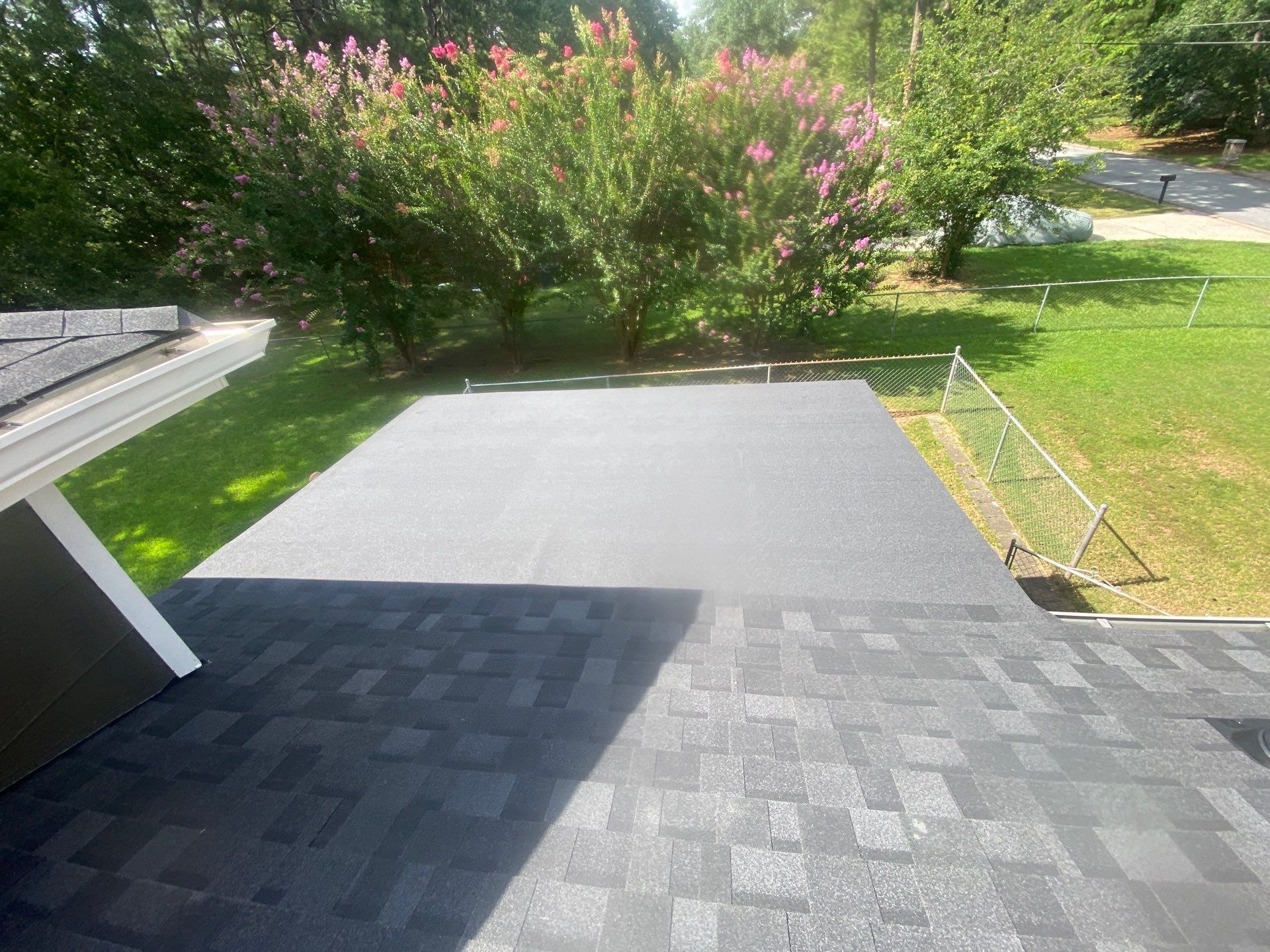 Trench dug in a grassy yard, leading to a house with black siding, and an electrical box.