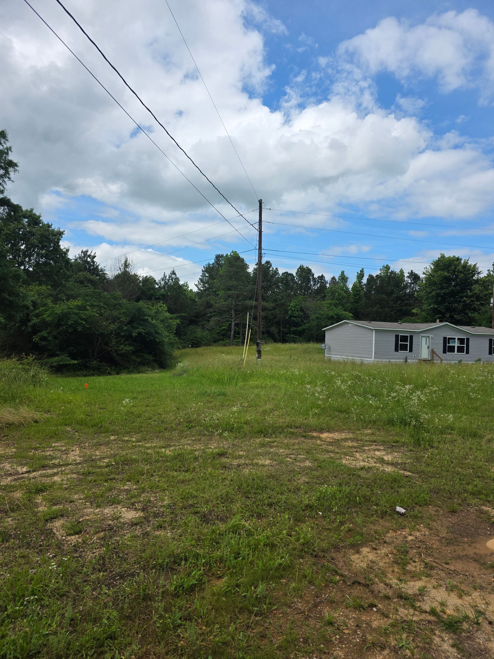 A large grassy field with a house in the background