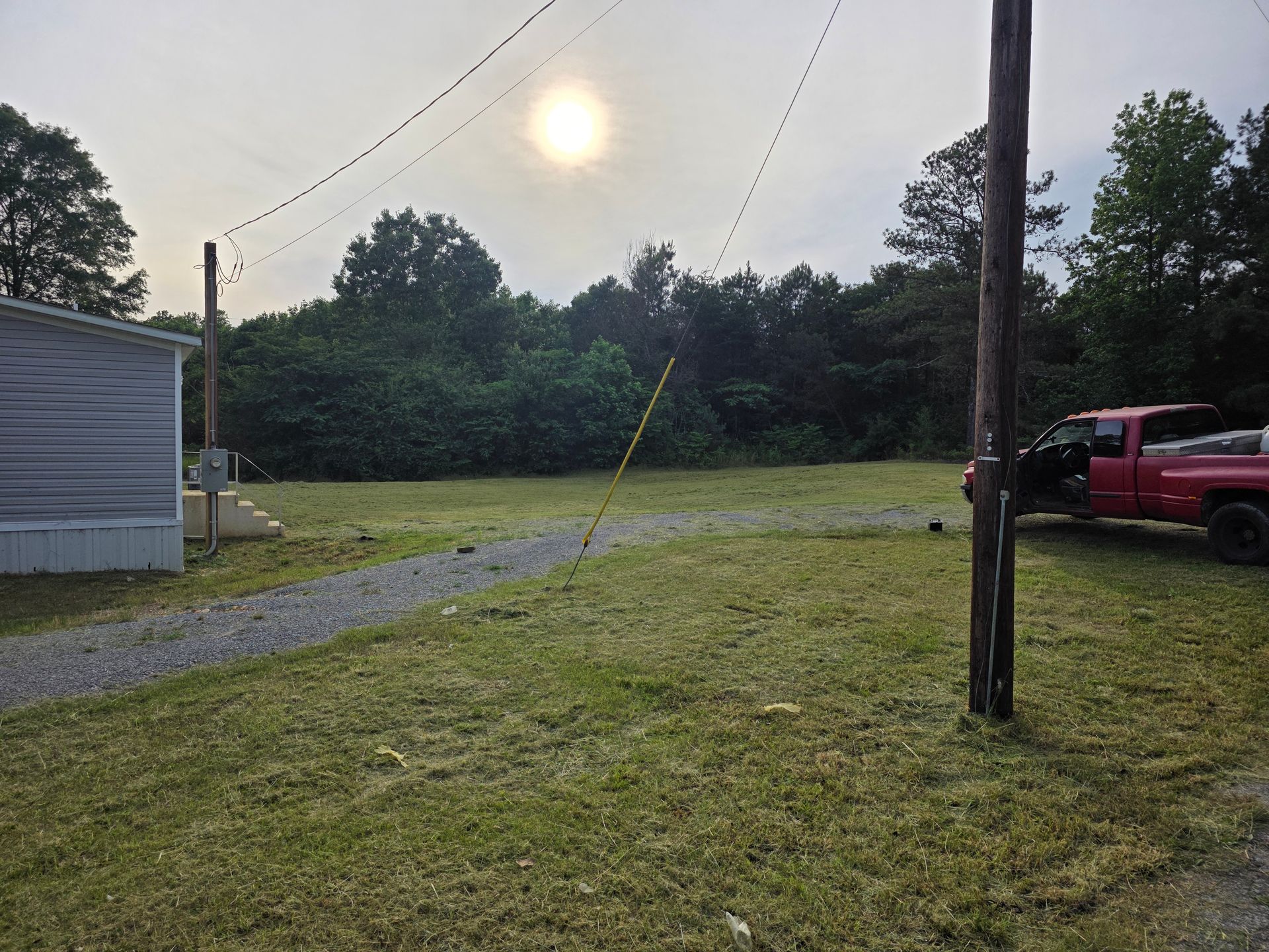 A red truck is parked in a grassy field.