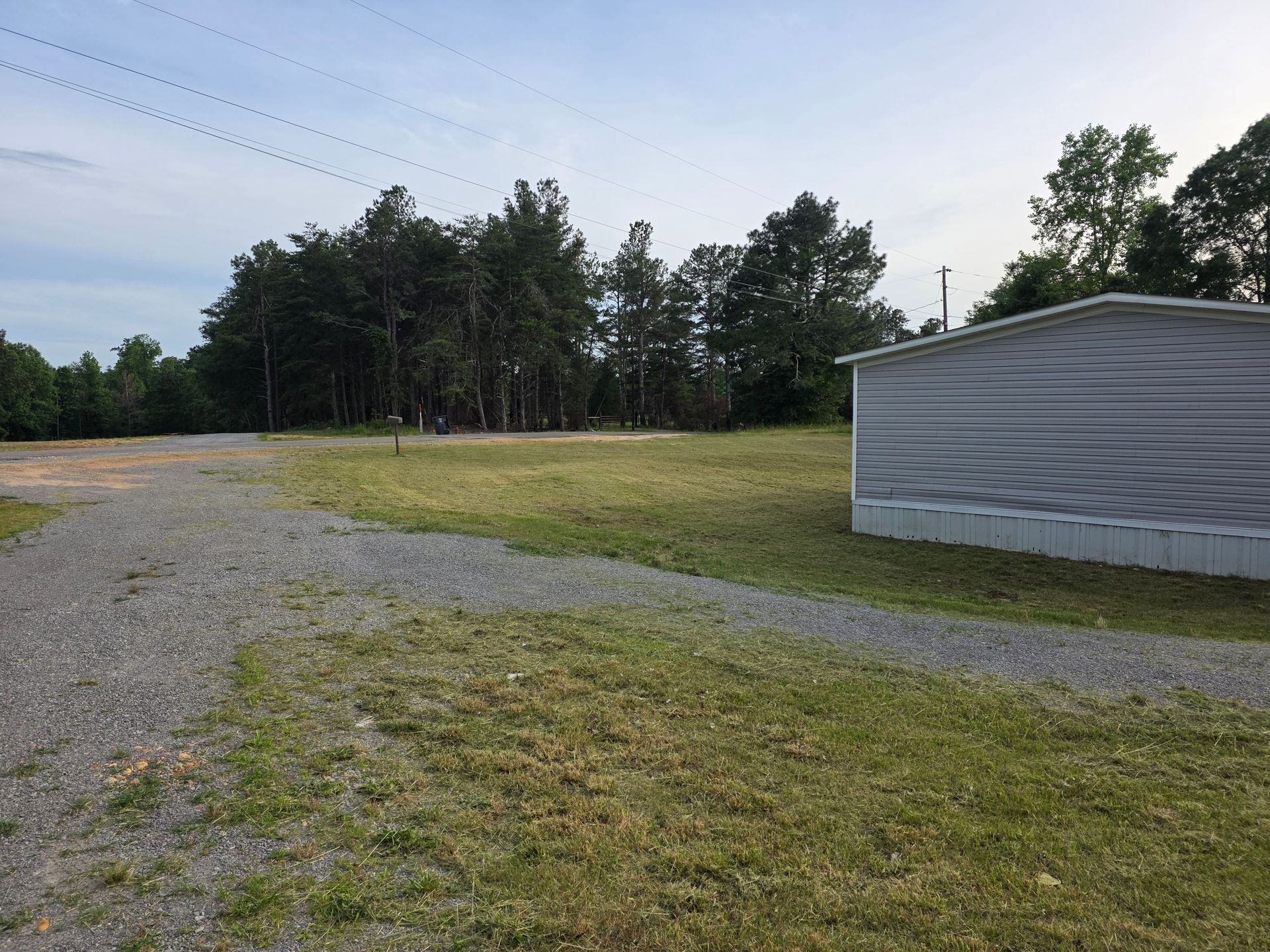 There is a shed in the middle of a grassy field.