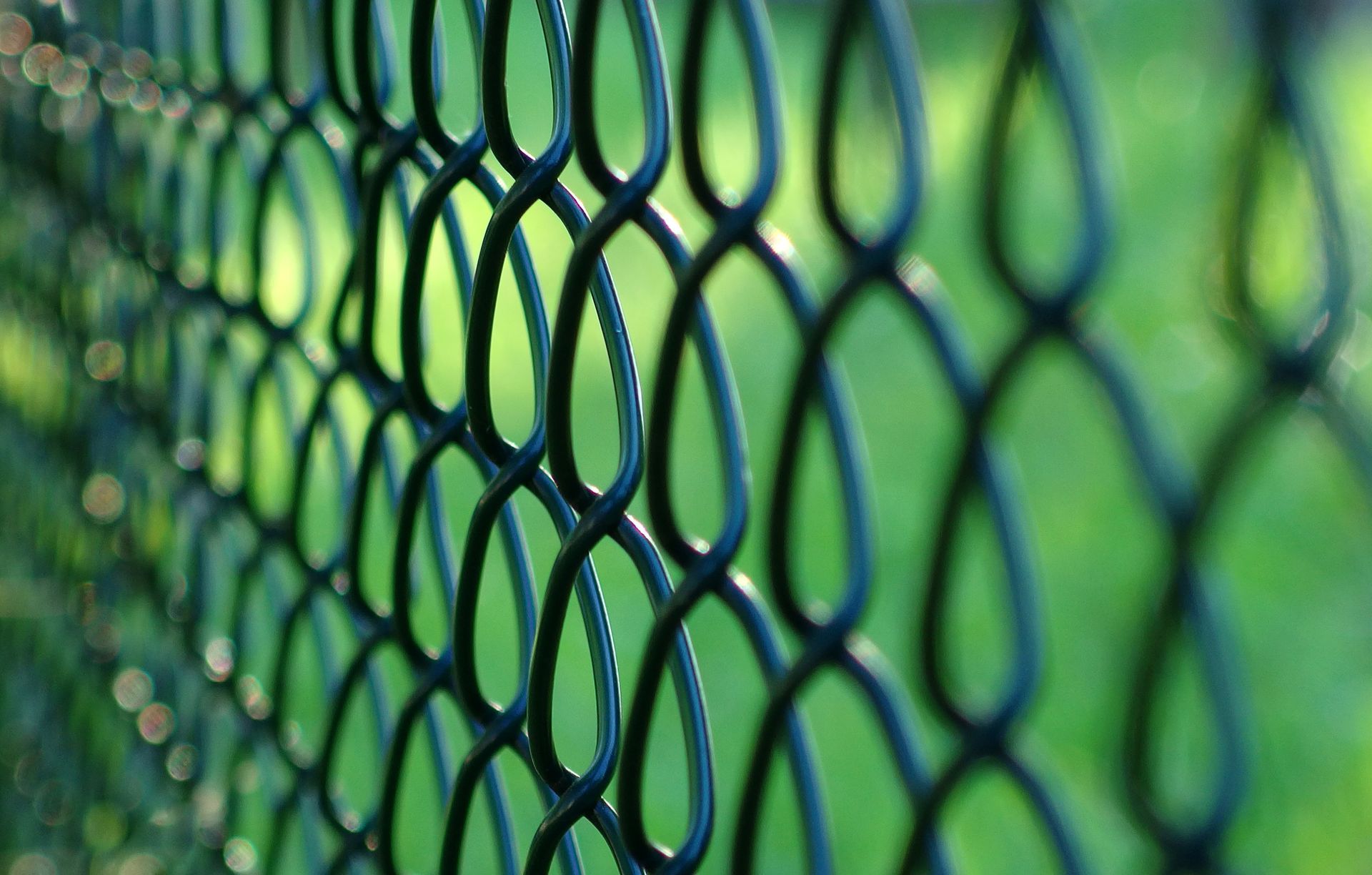 Close-up of a temporary chain-link fence with green background in Highland Park, TX, provided by A &