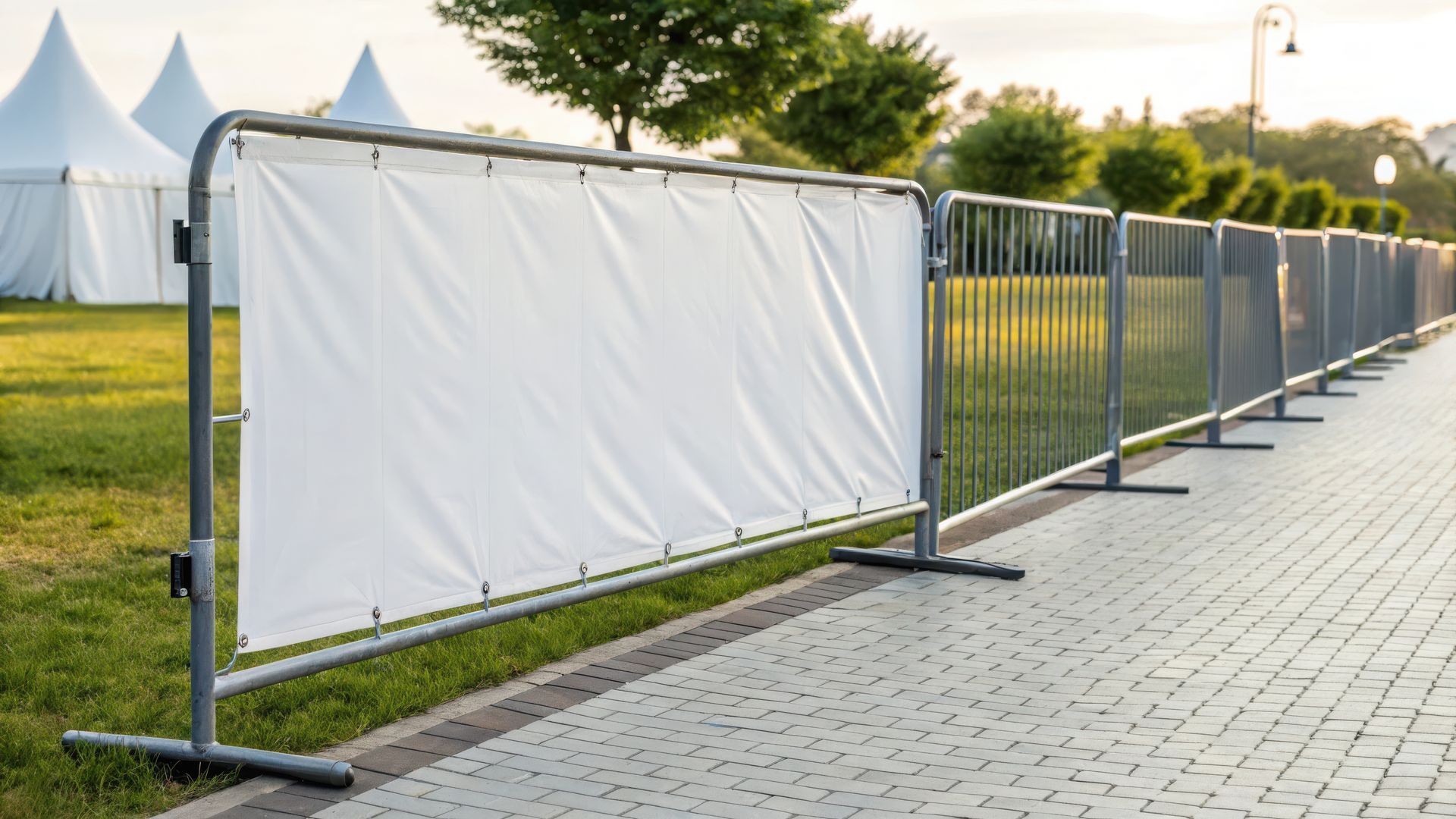 A large white screen is positioned in front of temporary event fencing, set for an upcoming event. A large white screen is positioned in front of temporary event fencing, set for an upcoming event.