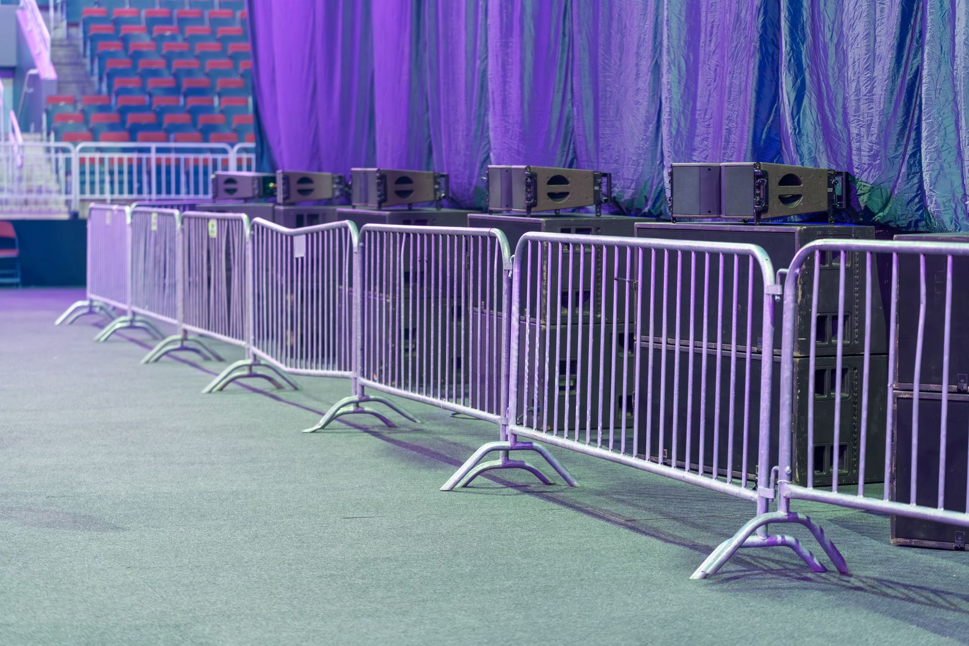 Security barriers arranged in front of stage equipment inside an indoor event venue. Security barriers arranged in front of stage equipment inside an indoor event venue.