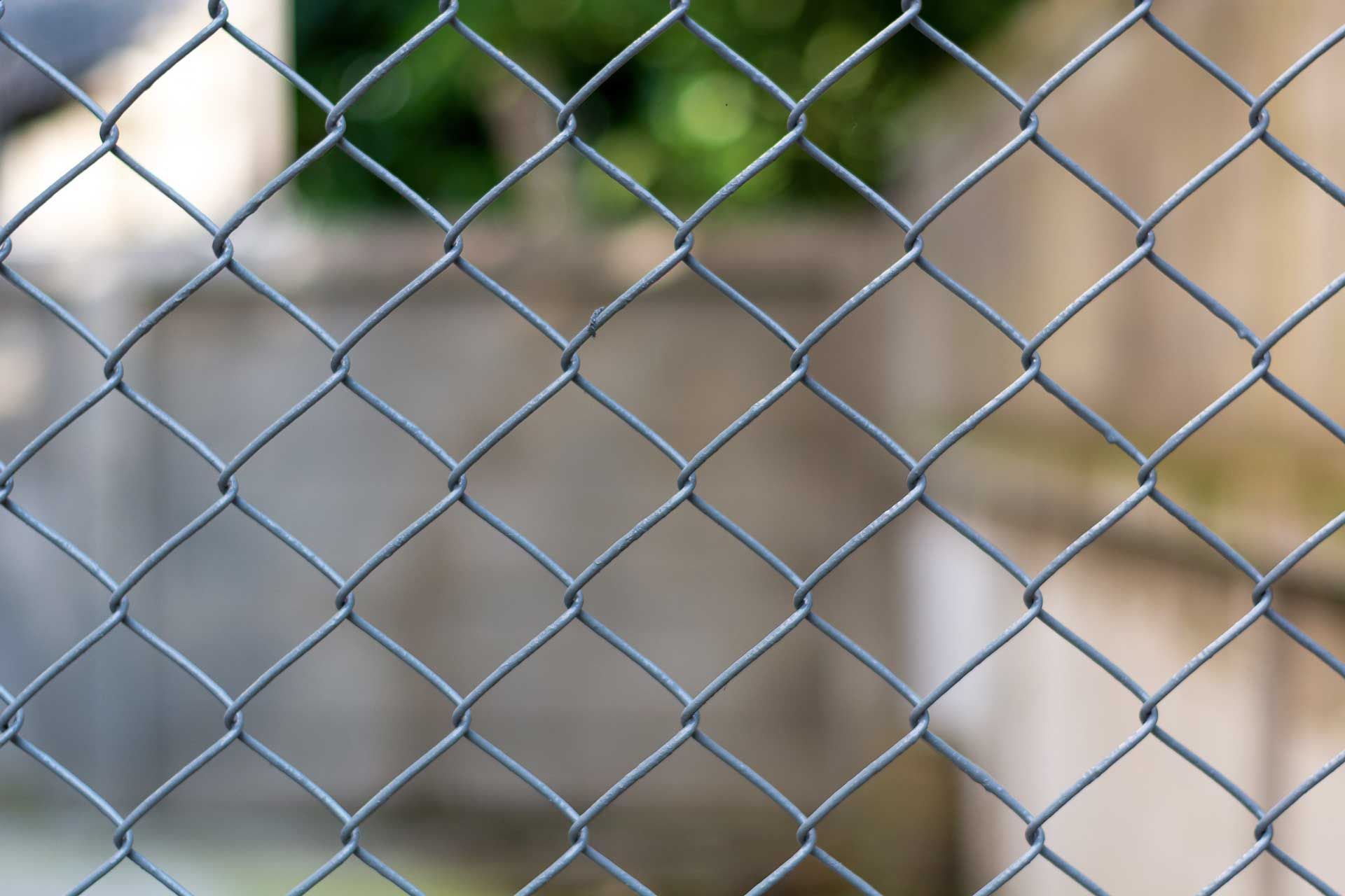Close-up view of chain-link temporary construction fence used for site security. Close-up view of chain-link temporary construction fence used for site security.