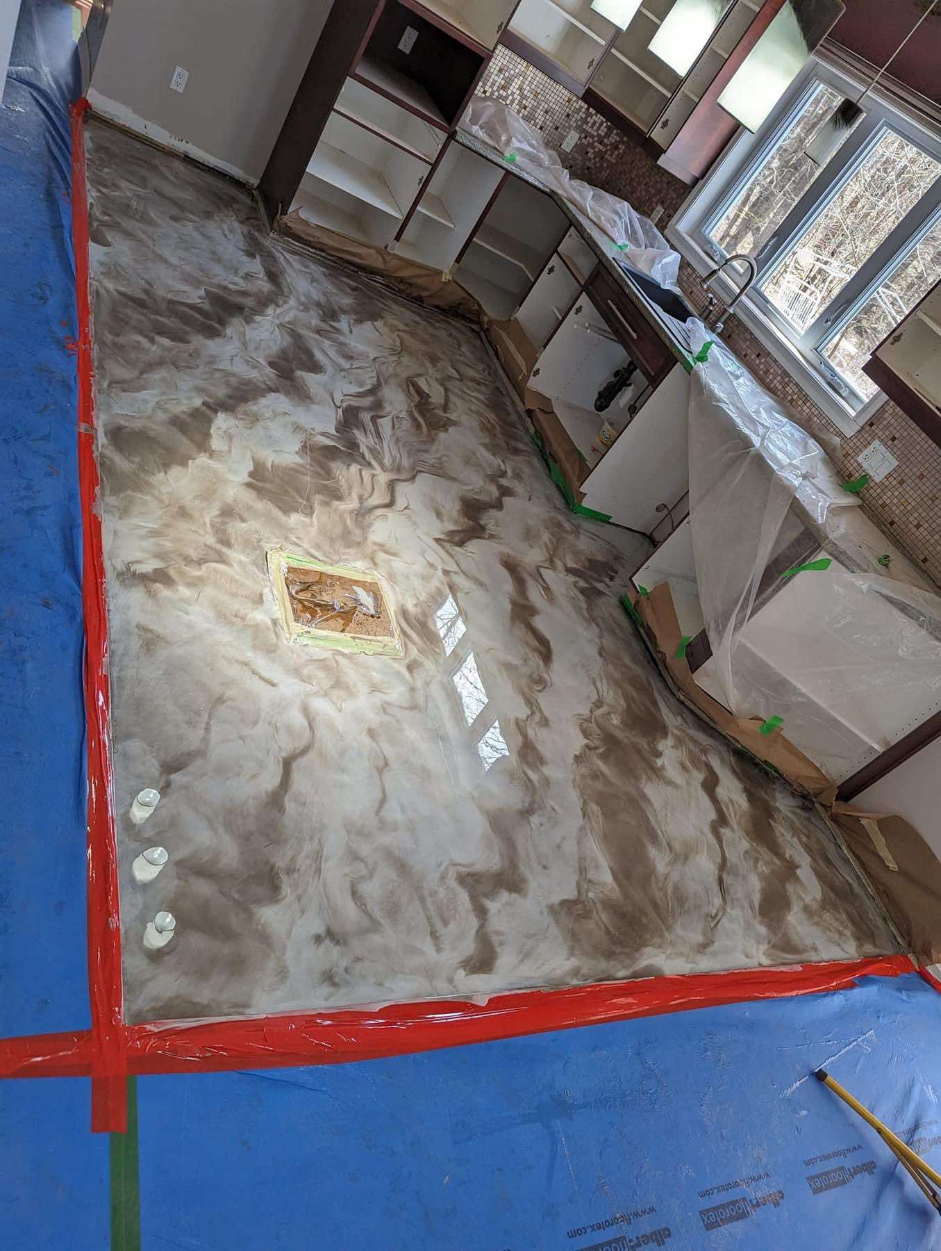 Un sol de cuisine est en train d'être peint dans une maison.