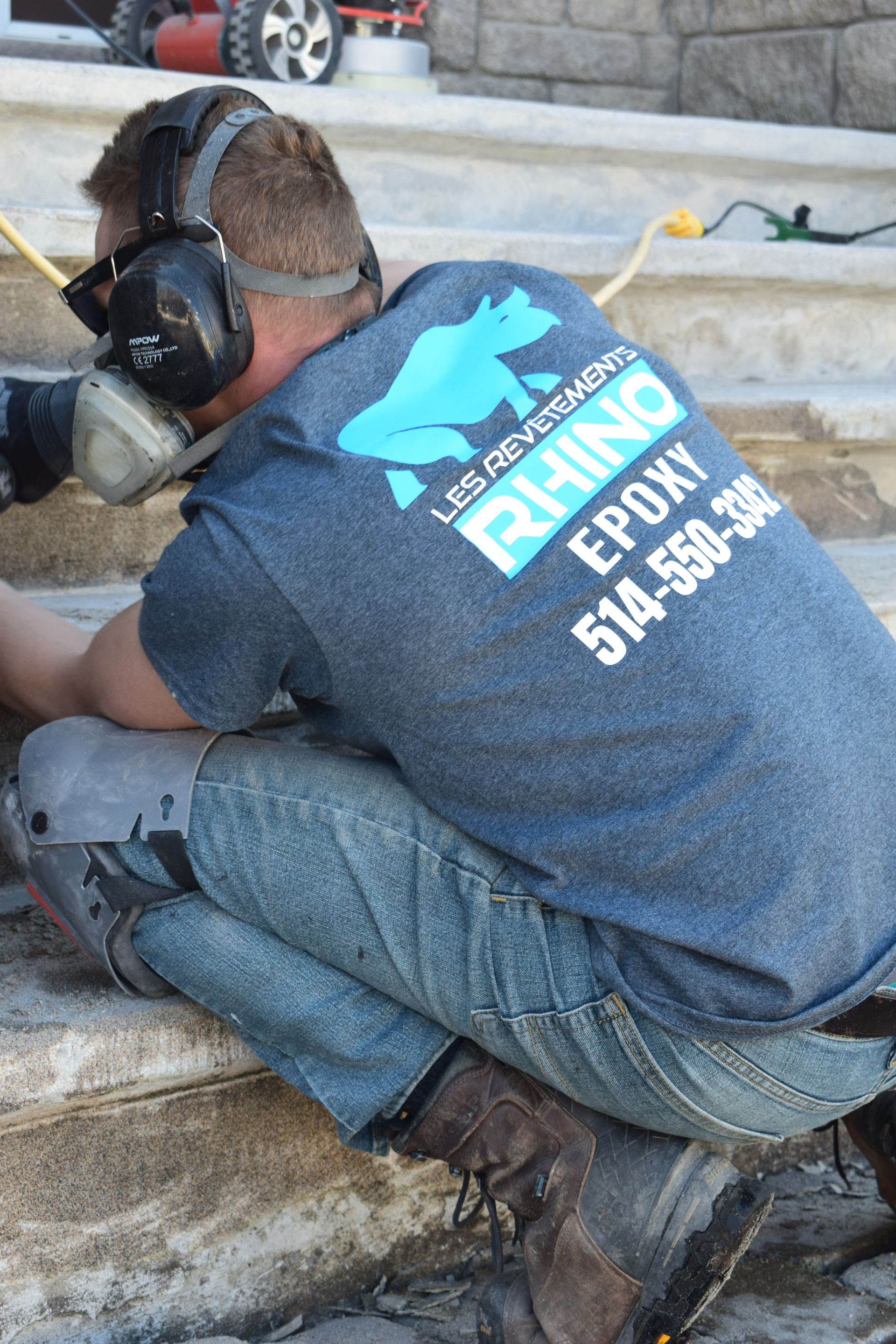 Un homme portant des écouteurs et une chemise en époxy rhinocéros est à genoux