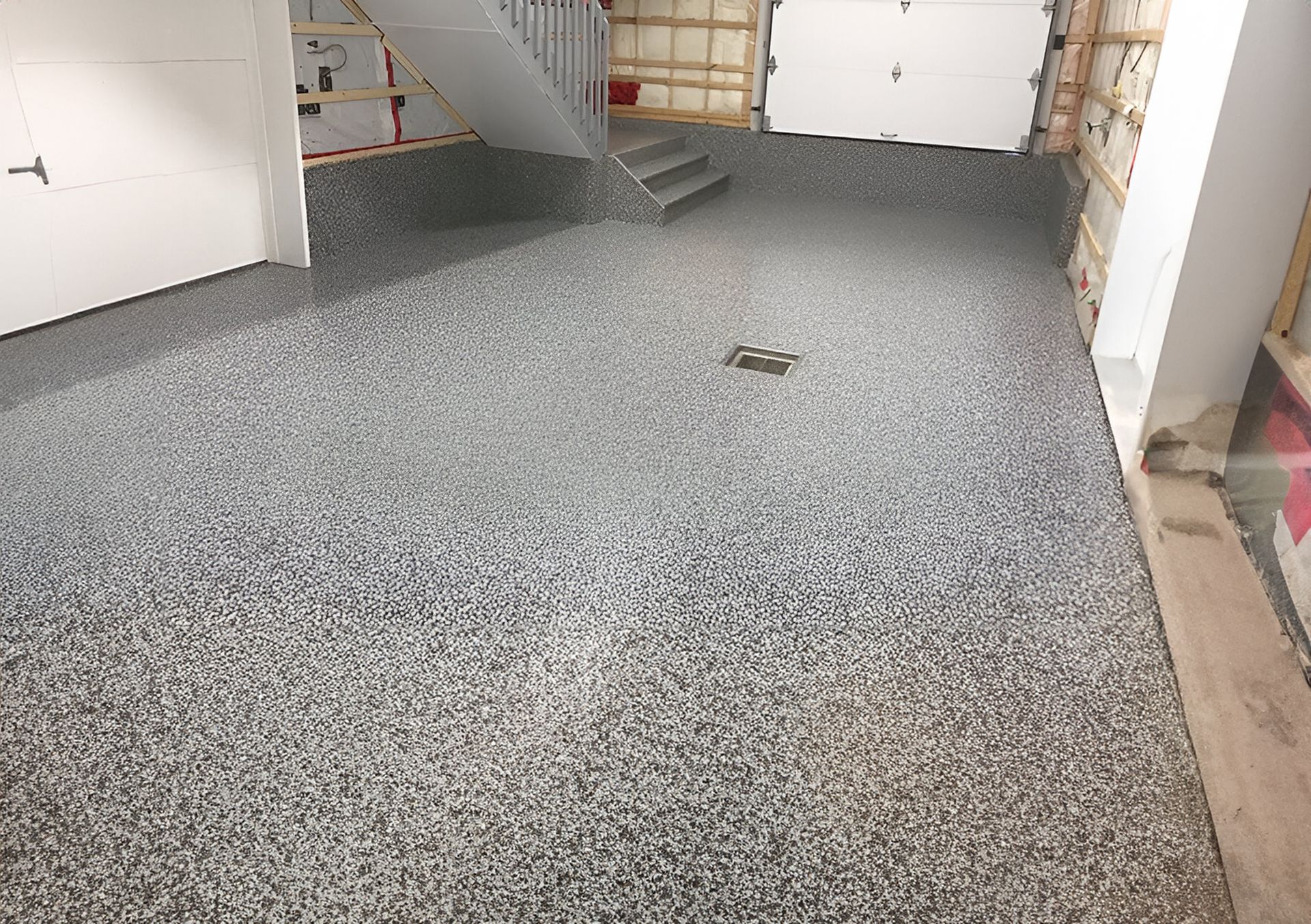 Revêtement de sol époxy moucheté gris dans un cadre résidentiel.
