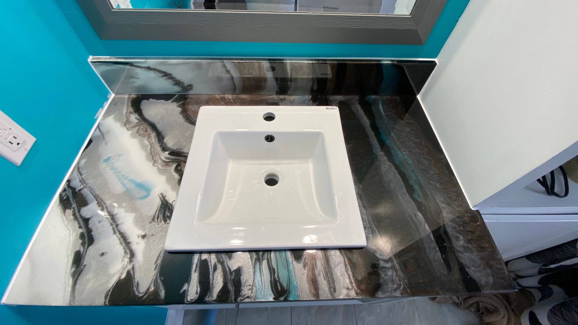 Un lavabo de salle de bain avec un plan de travail en marbre et un miroir.