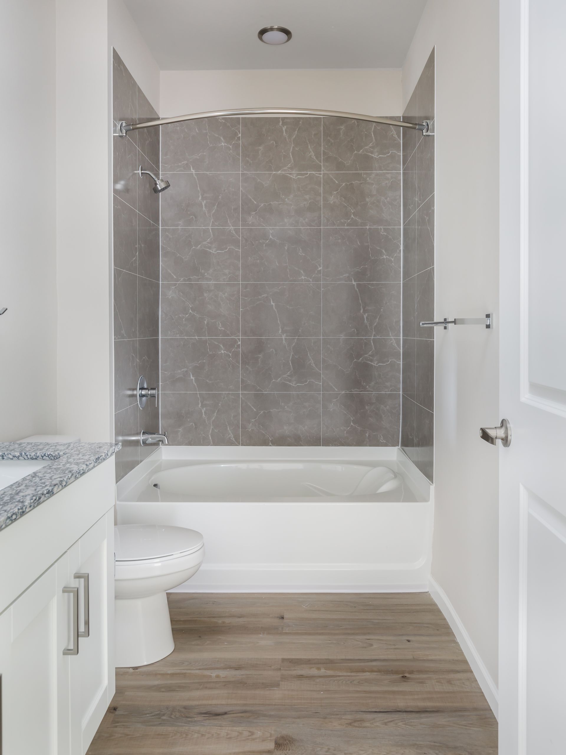 A bathroom with a tub , toilet , sink and shower.