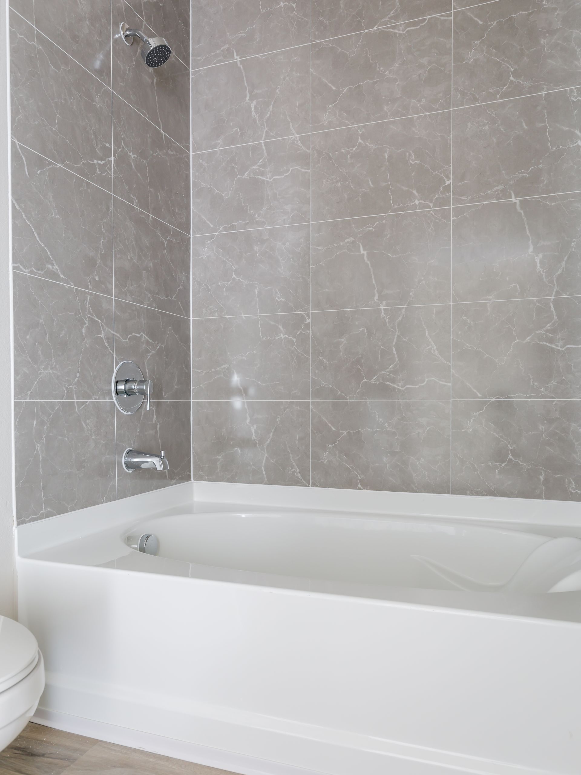 There is a bathtub in the bathroom next to a toilet.