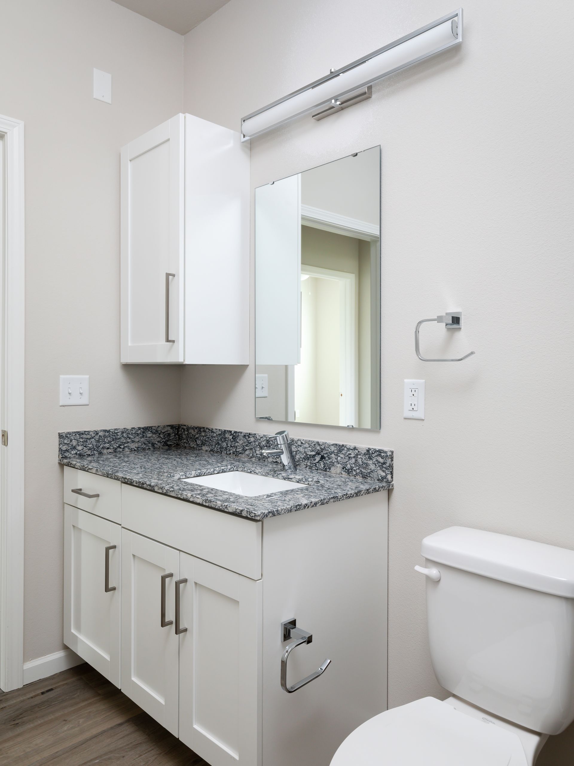 A bathroom with a toilet a sink and a mirror