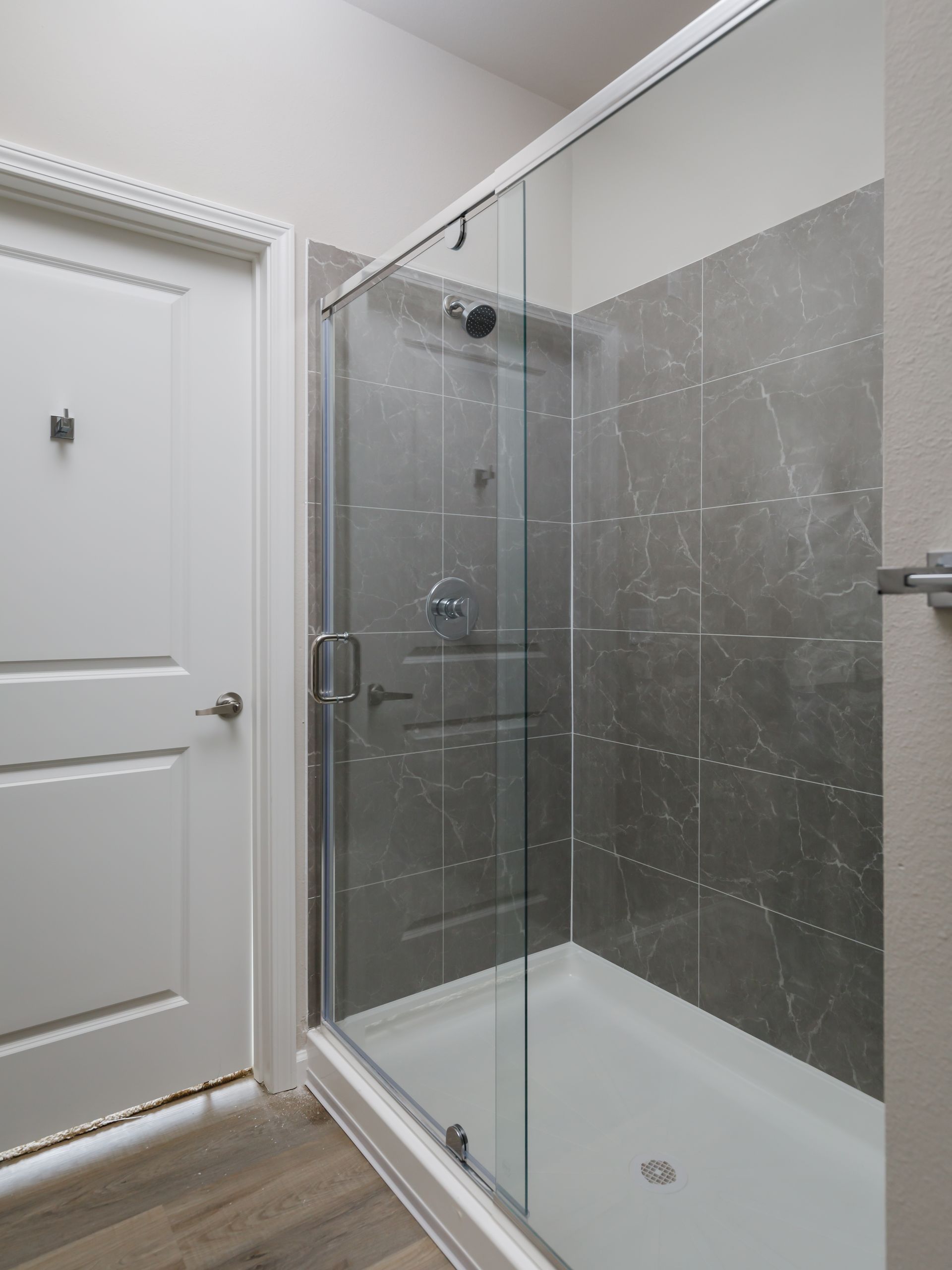 A bathroom with a sliding glass shower door and a bathtub.