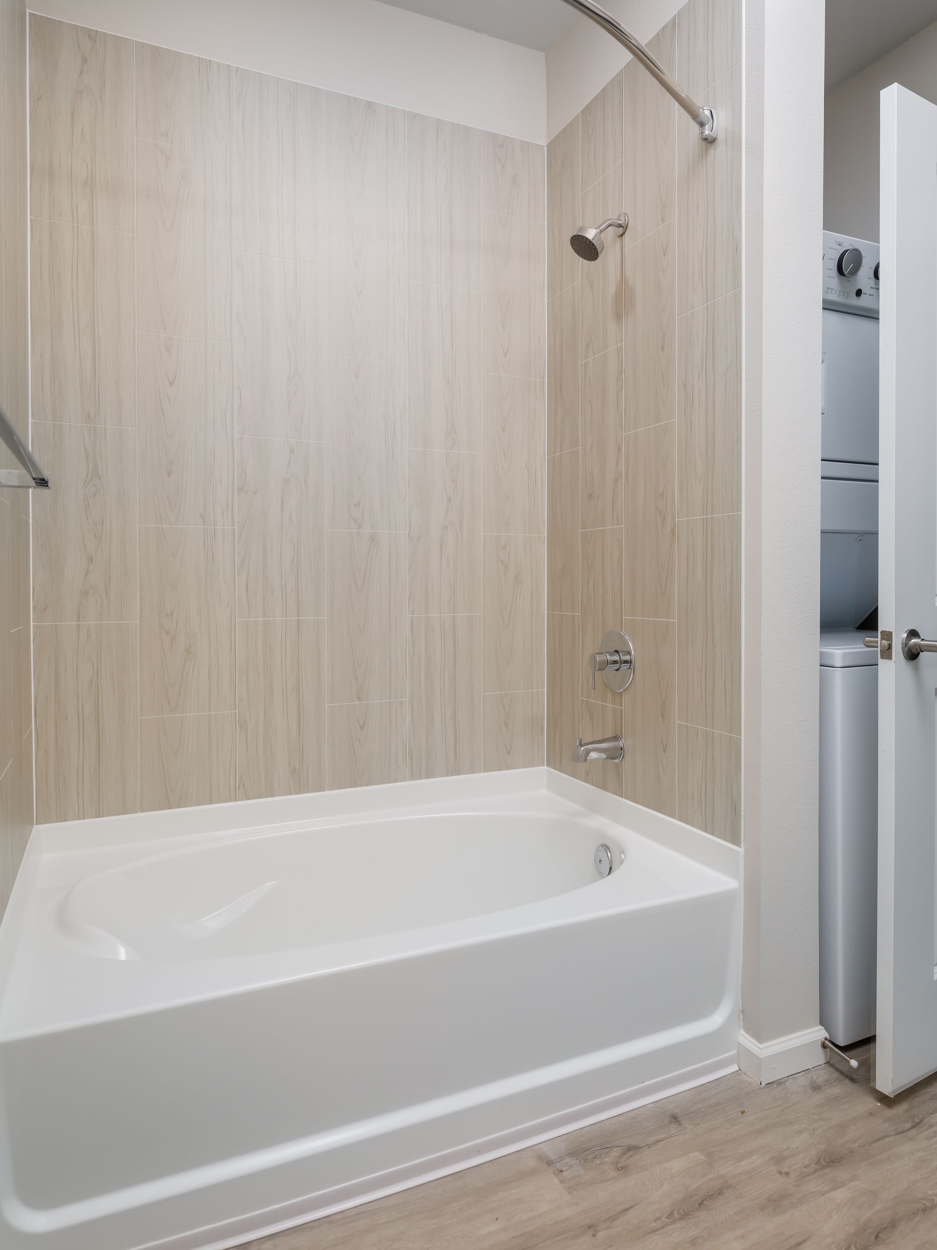 A bathroom with a bathtub and a washer and dryer.