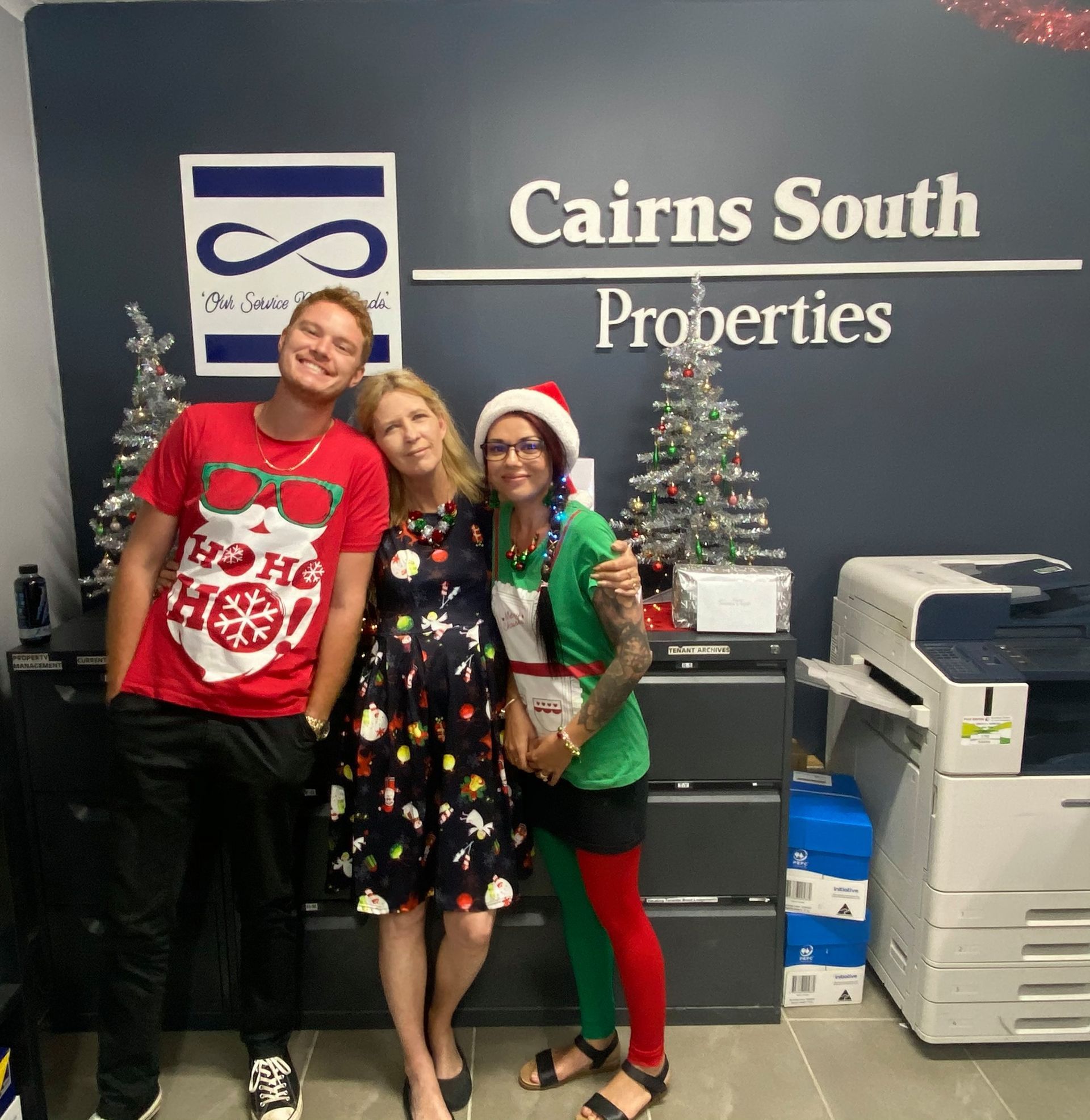 A Group of People Standing in Front of a Sign That Says Cairns South Properties — Cairns South Properties In Edmonton, QLD