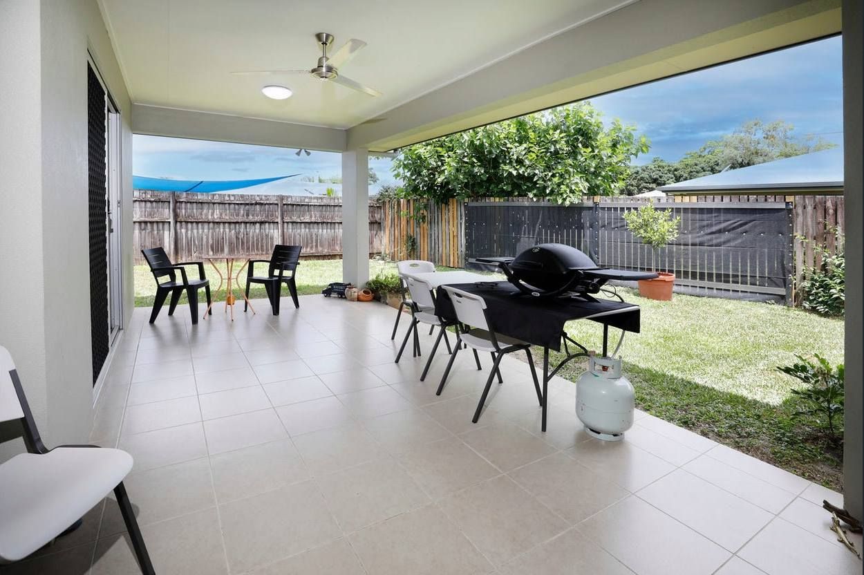 A Patio With A Table And Chairs And A Grill — Cairns South Properties In Edmonton, QLD