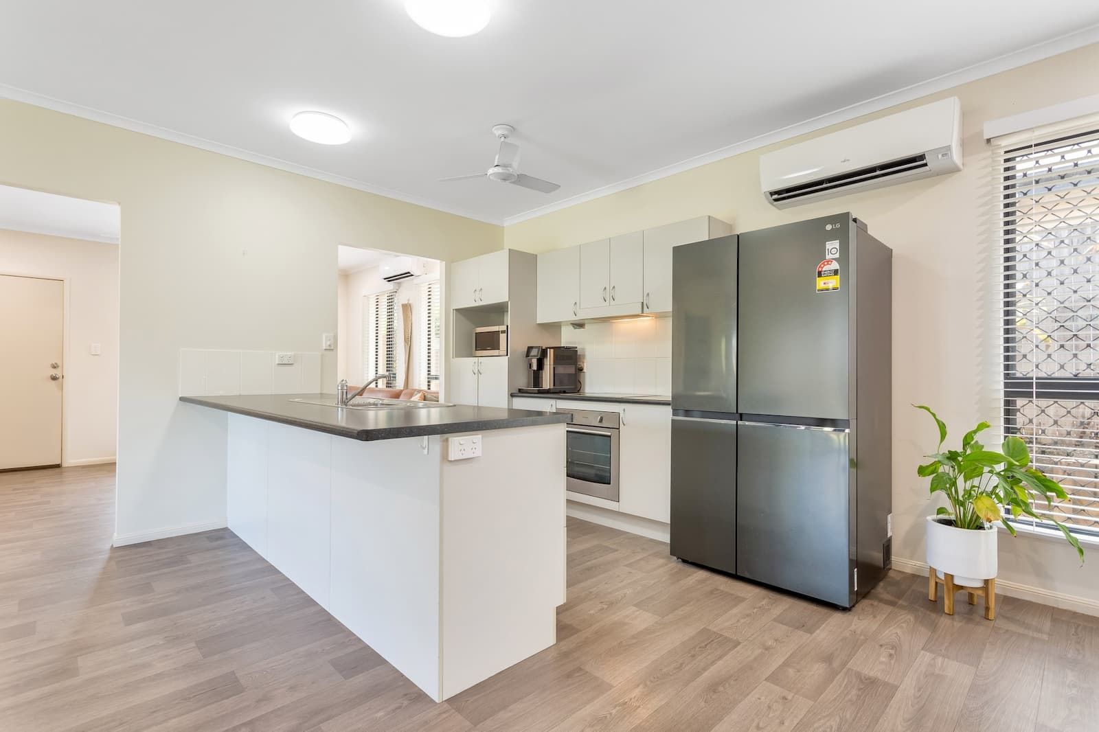 A Kitchen With A Stainless Steel Refrigerator — Cairns South Properties In Bentley Park, QLD