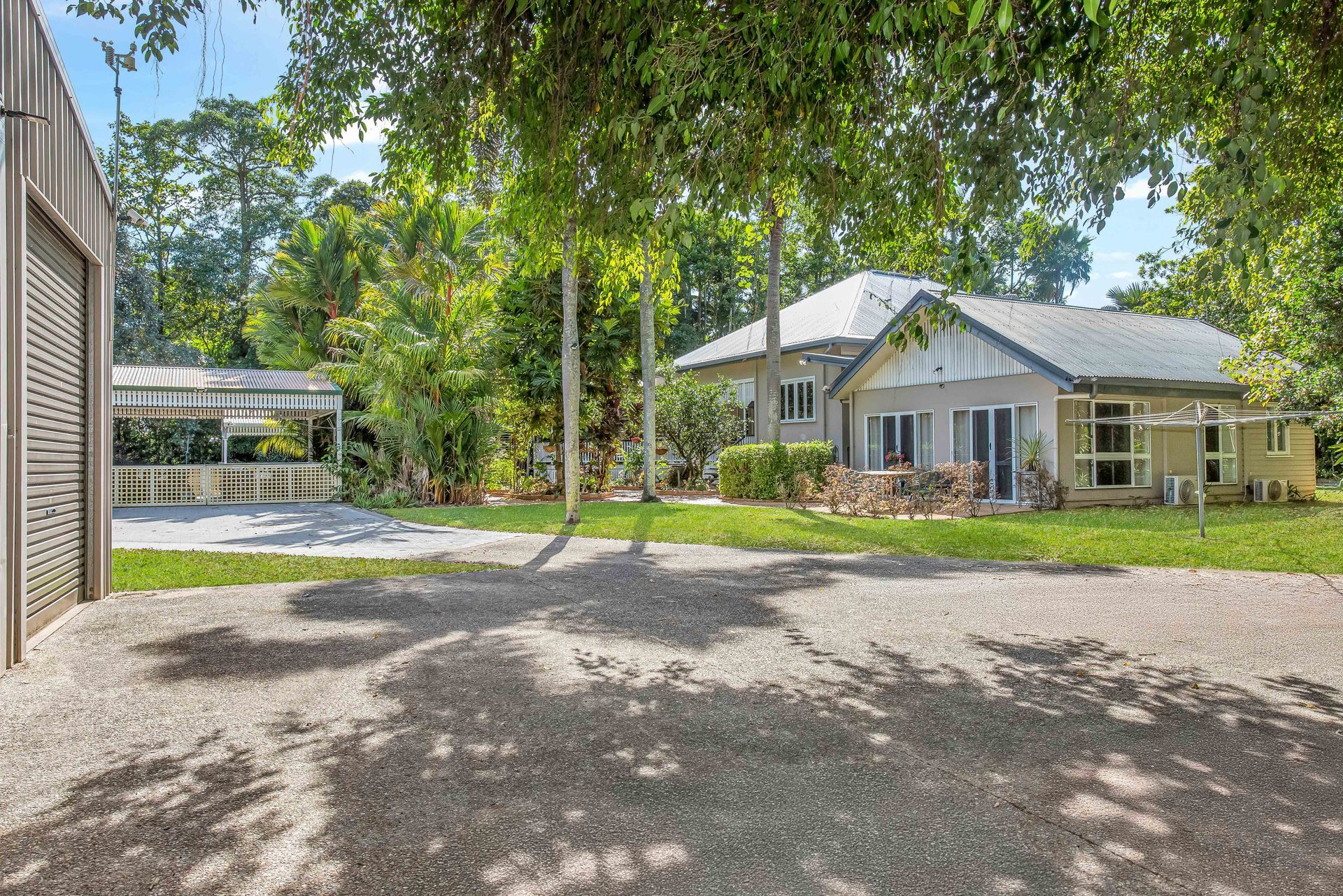 A Large Swimming Pool Is Surrounded By A Brick Patio And A Black Canopy — Cairns South Properties In Edmonton, QLD