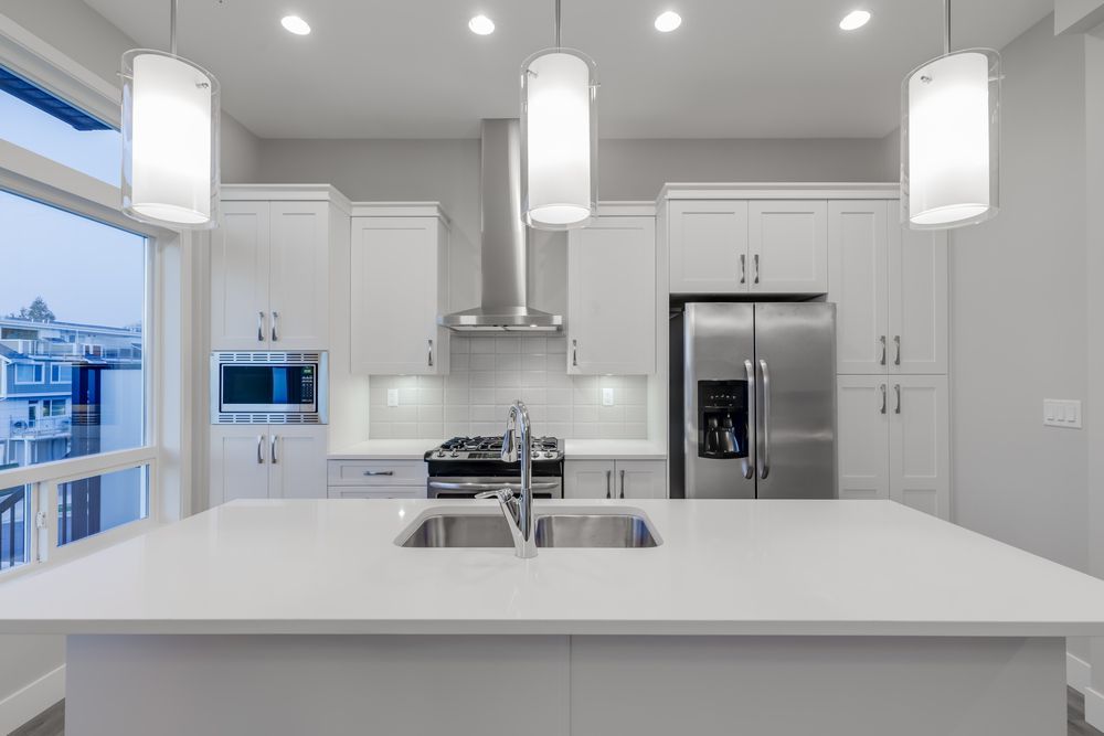 A Kitchen With White Cabinets, Stainless Steel Appliances — Cairns South Properties In Edmonton, QLD