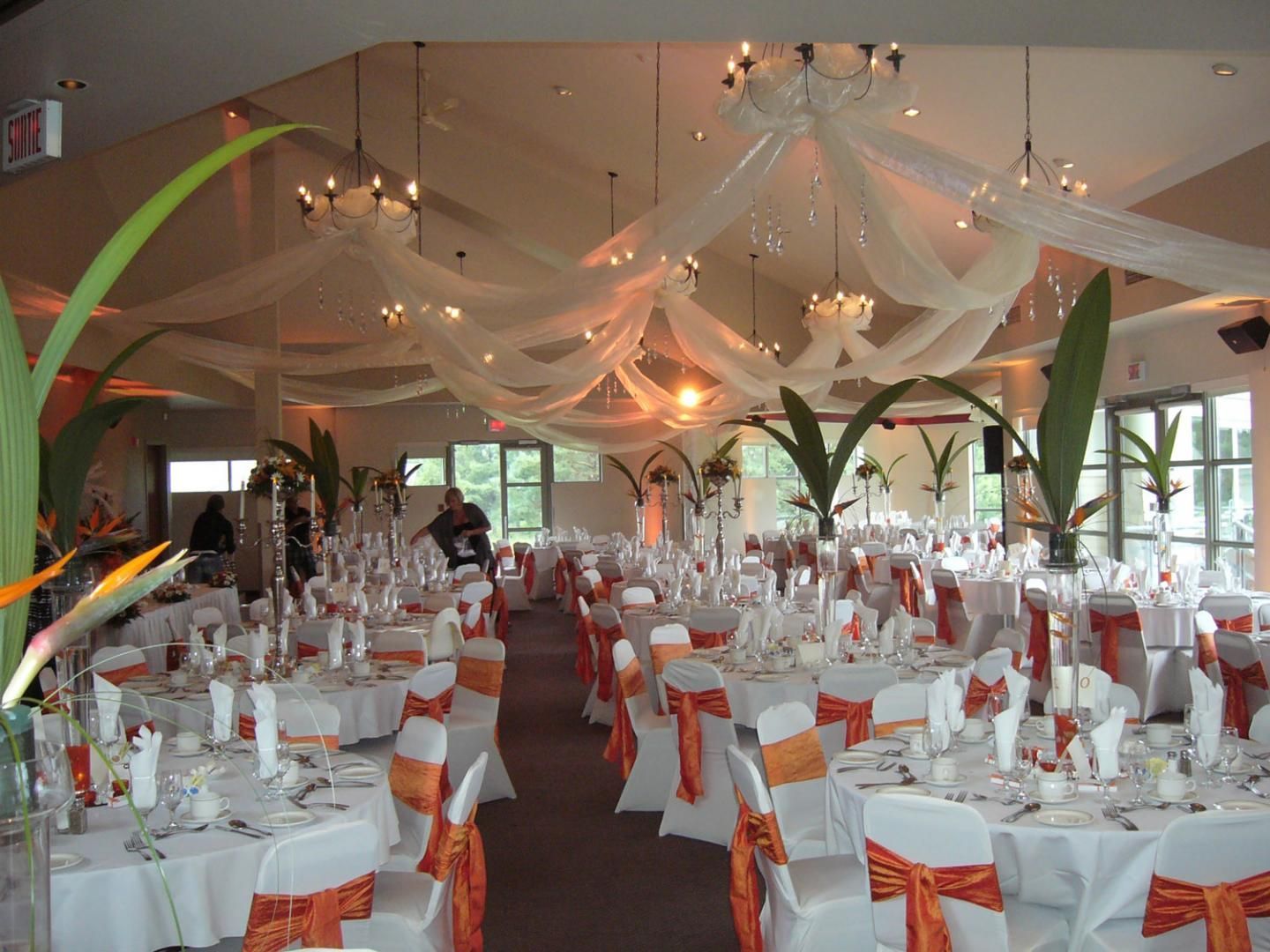 Une grande salle avec des tables et des chaises installées pour une réception de mariage