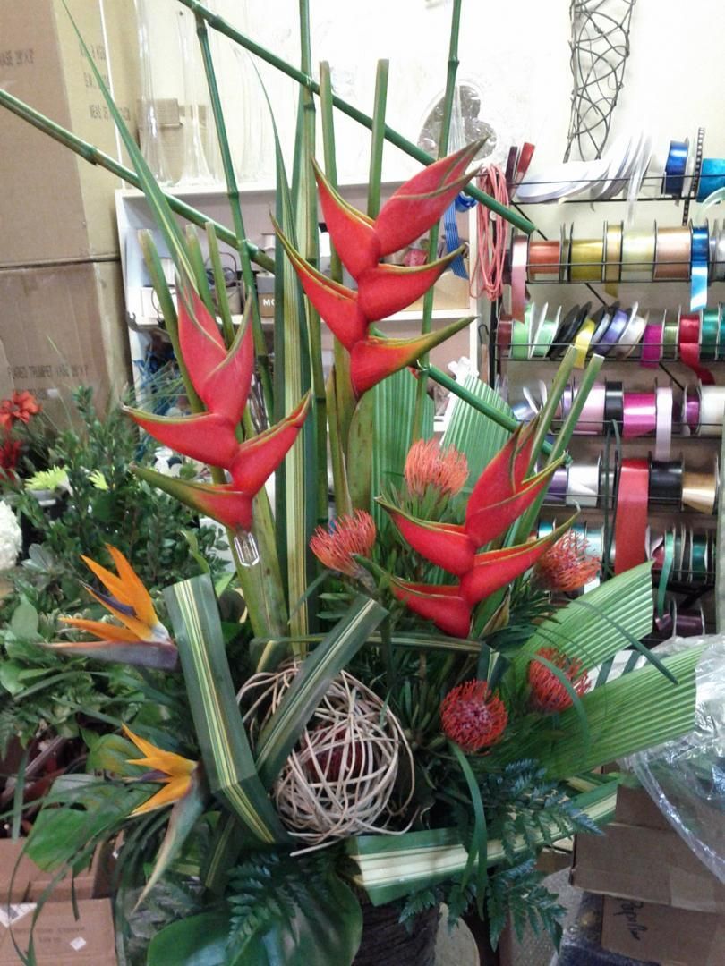 Un bouquet de fleurs rouges et de verdure dans un vase