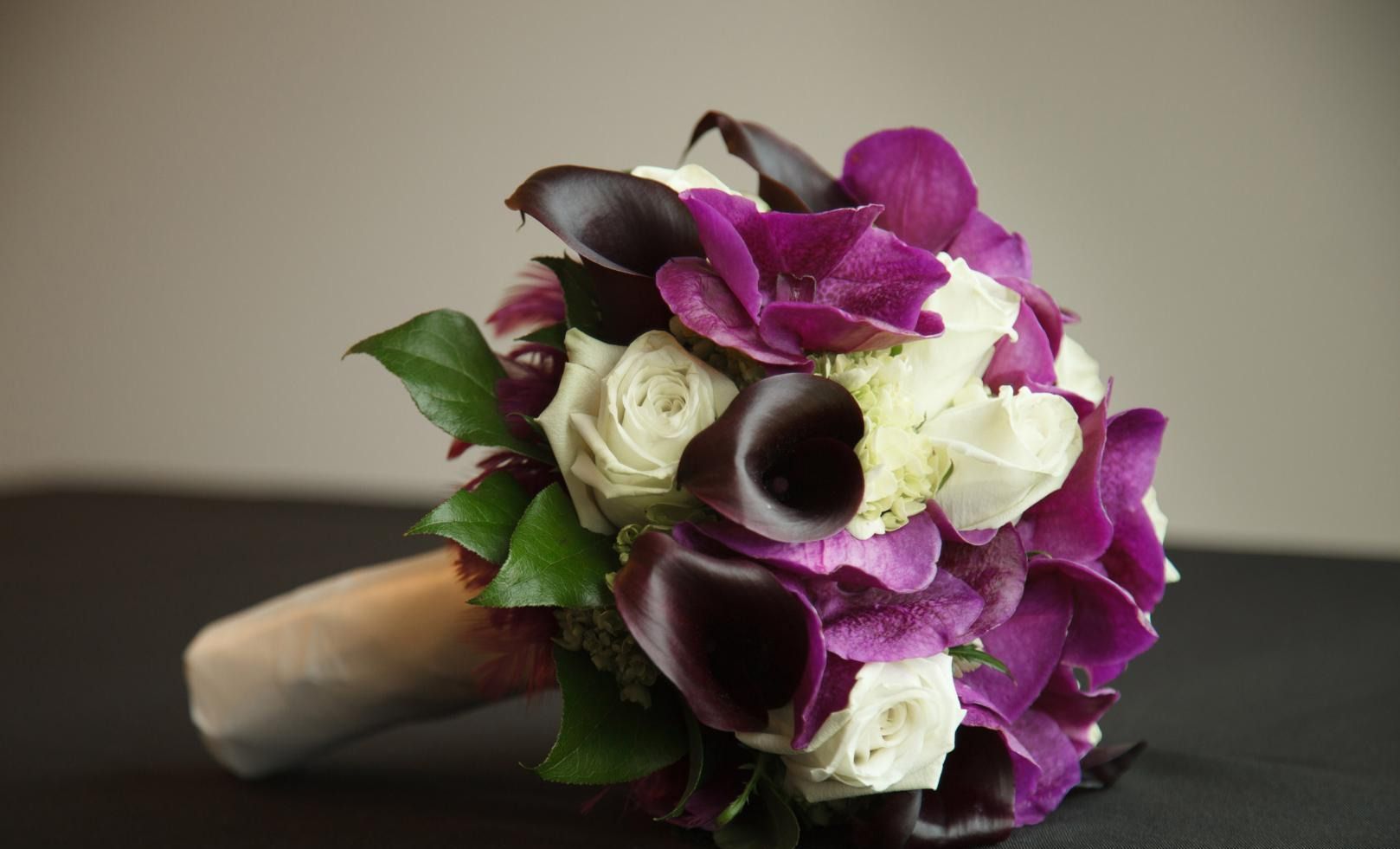 Un bouquet de fleurs violettes et blanches est posé sur une table.