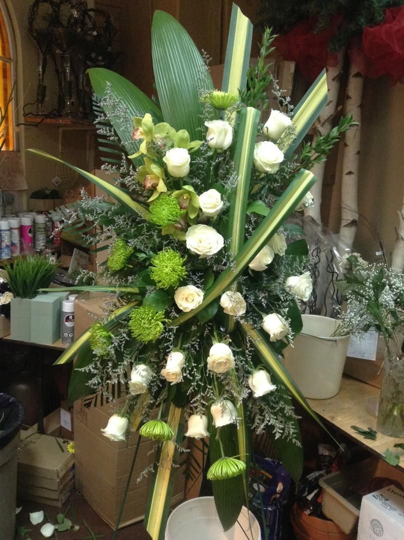 Un grand bouquet de roses blanches et de verdure est posé sur une table.
