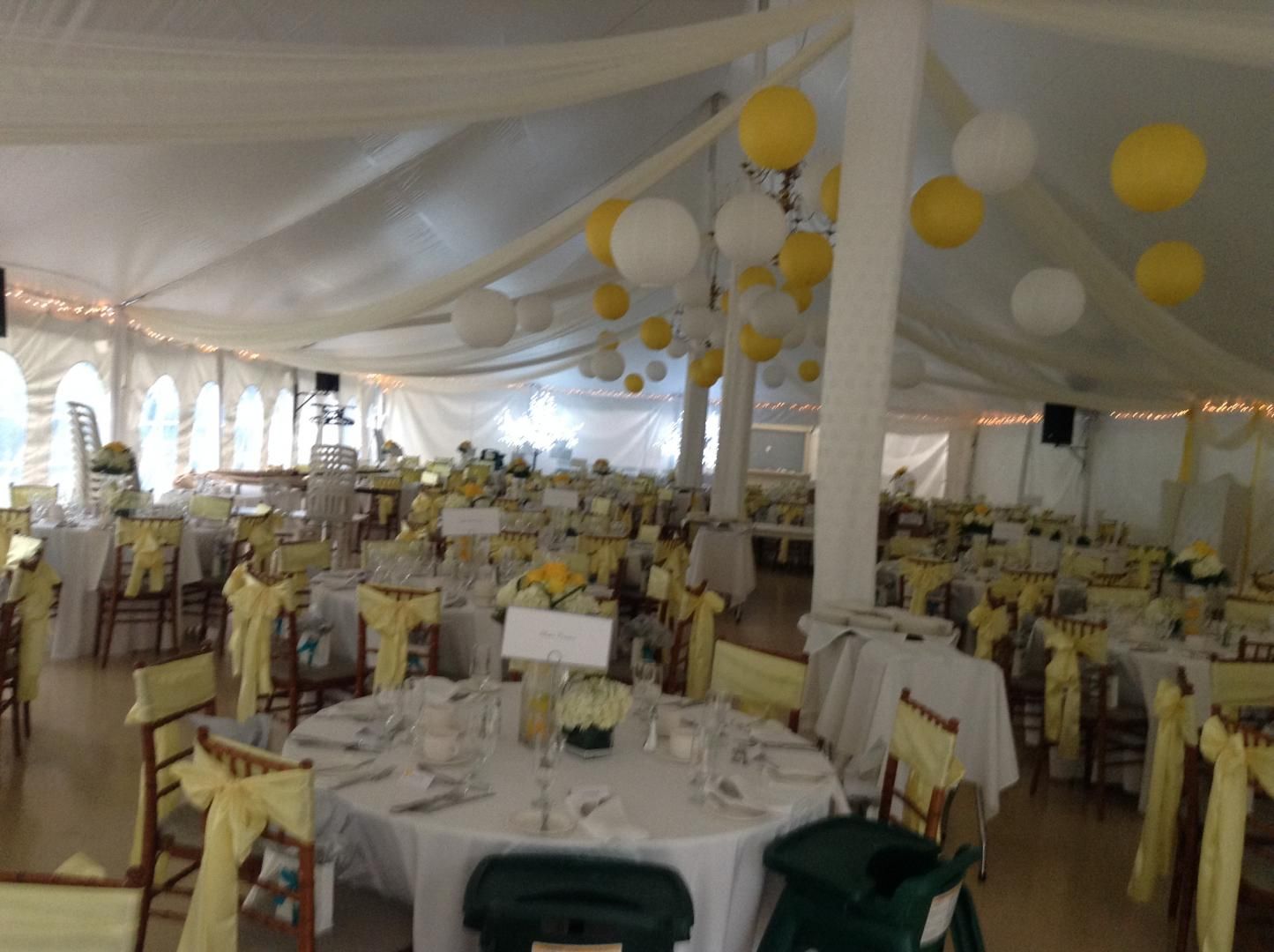 Une grande salle avec tables et chaises installées pour une réception de mariage.