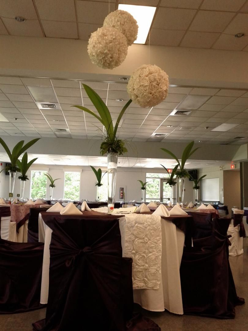 Une grande salle avec des tables et des chaises installées pour une réception de mariage
