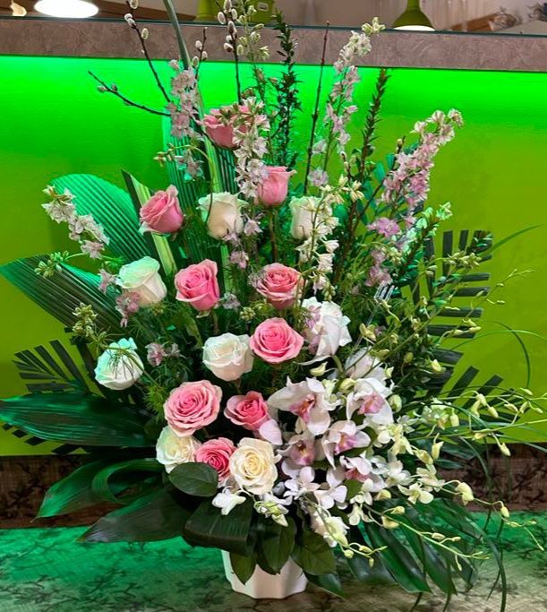 Un vase rempli de fleurs roses et blanches est posé sur une table.