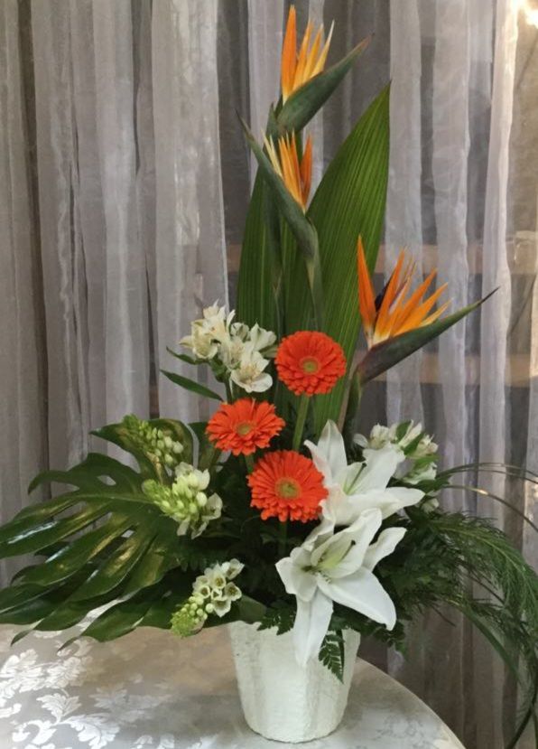 Un vase rempli de fleurs est posé sur une table.