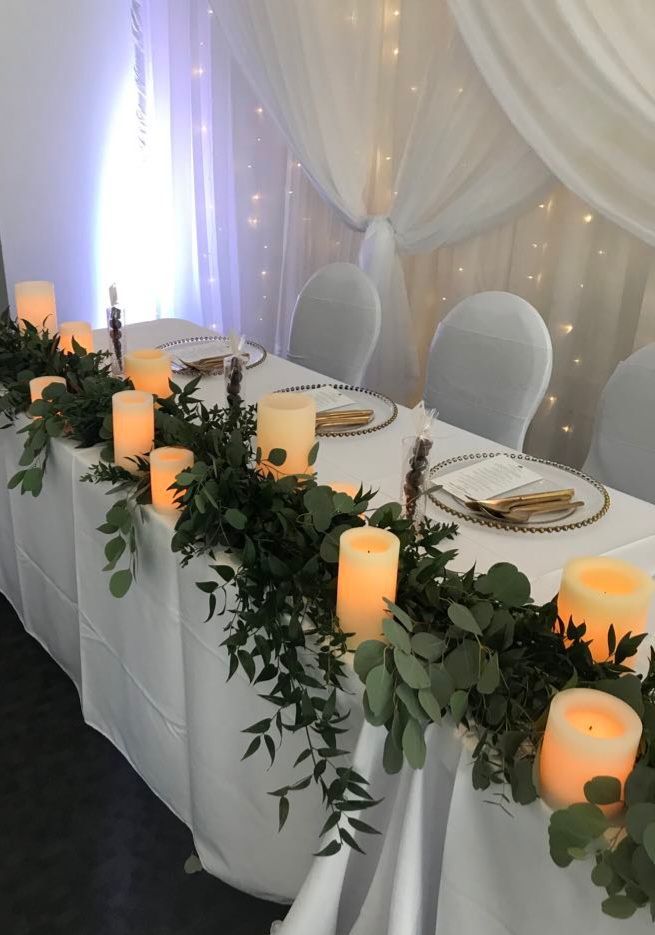 Une longue table avec des bougies et des fleurs dessus.