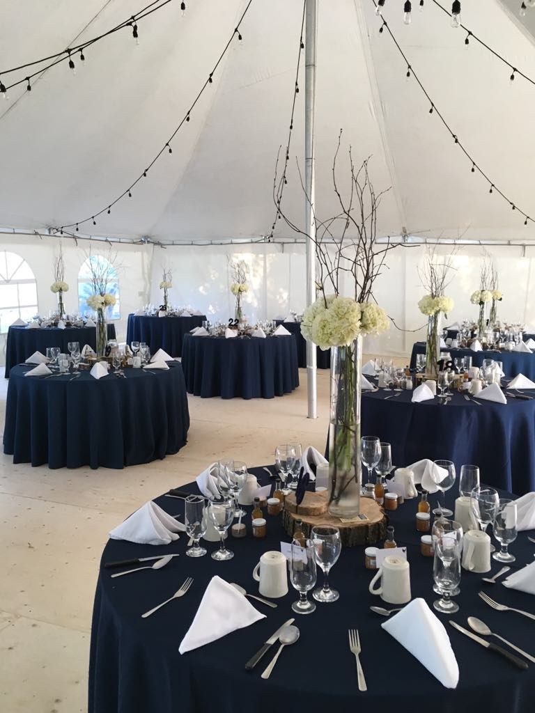 Une grande tente avec des tables dressées pour une réception de mariage