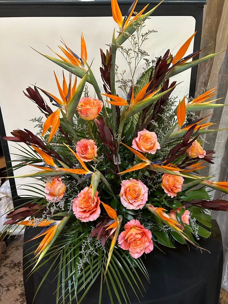Un grand bouquet de fleurs est posé sur une table noire.