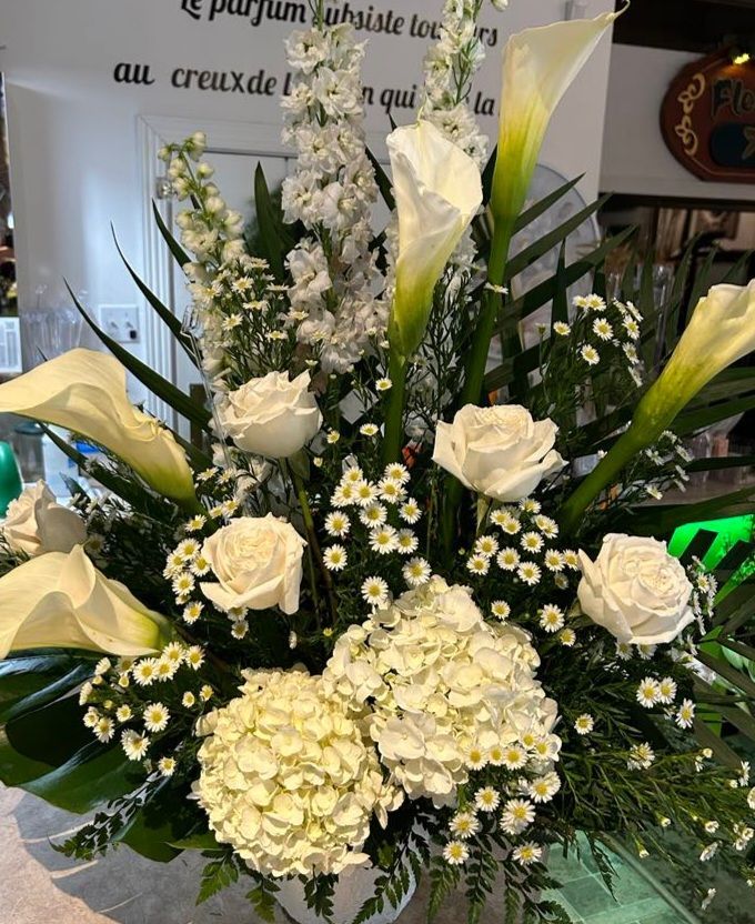 Un grand bouquet de fleurs blanches est posé sur une table