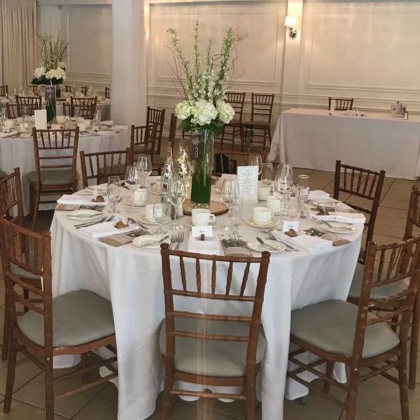 Une grande salle avec des tables et des chaises installées pour une réception de mariage