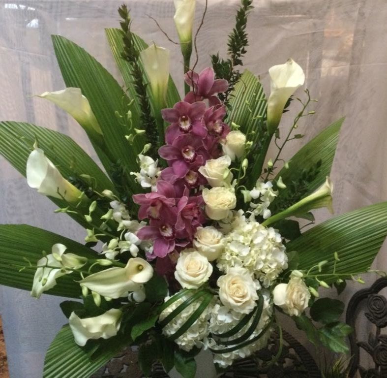 Un bouquet de fleurs blanches et violettes avec des feuilles vertes