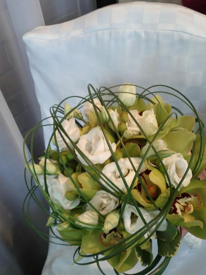 Un bouquet de fleurs est posé sur une chaise blanche