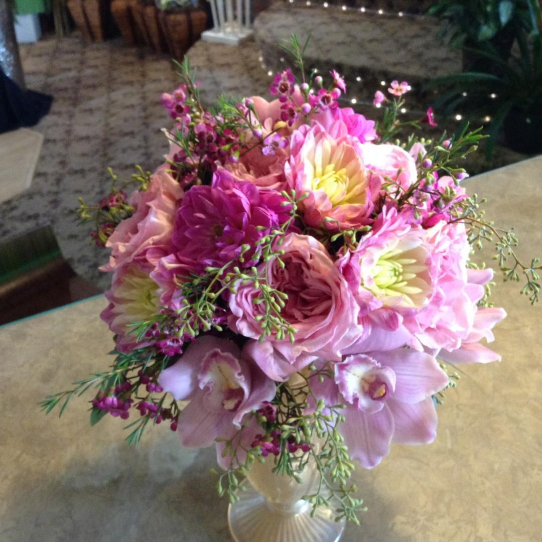 Un bouquet de fleurs roses dans un vase sur une table