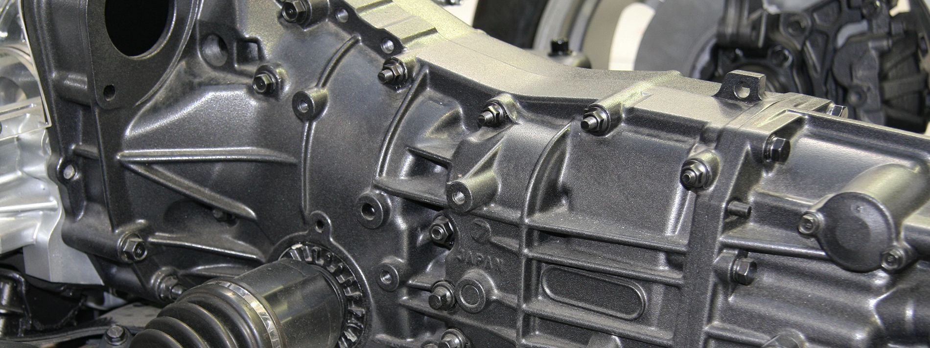 Dark gray Ford F-150 pickup truck parked on dirt road in front of trees.