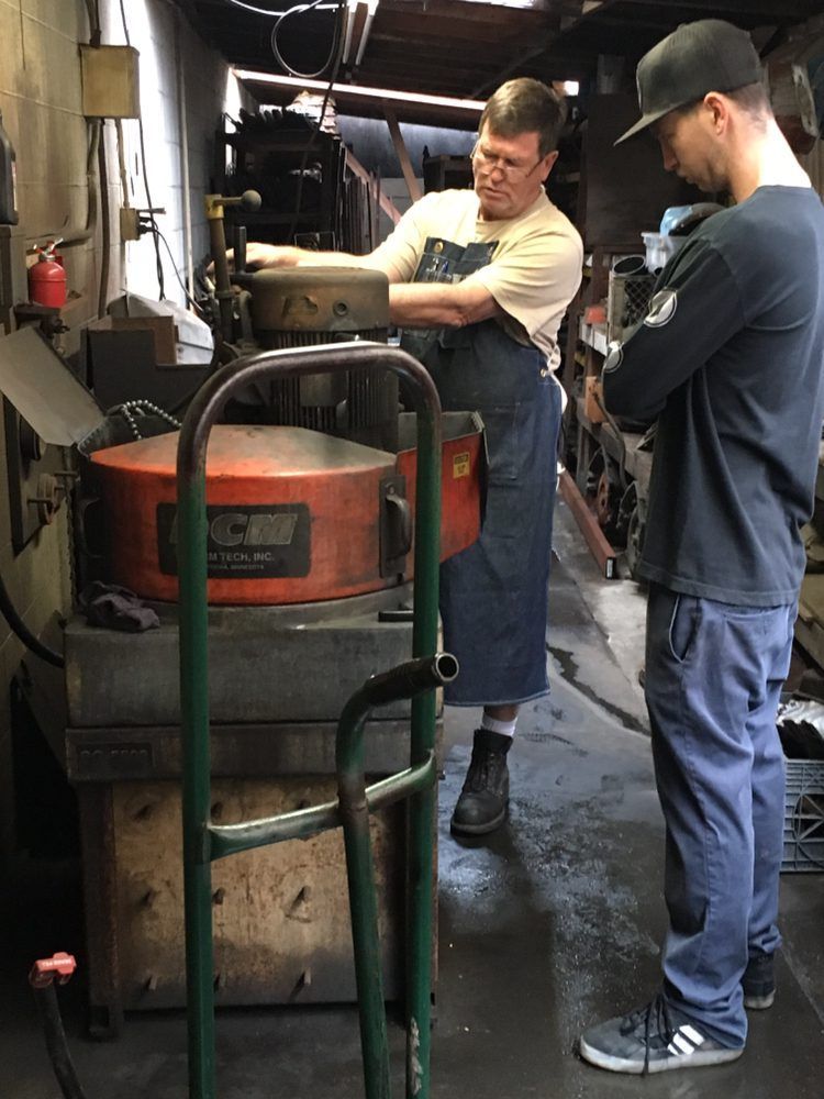 Two men are working on a machine in a factory