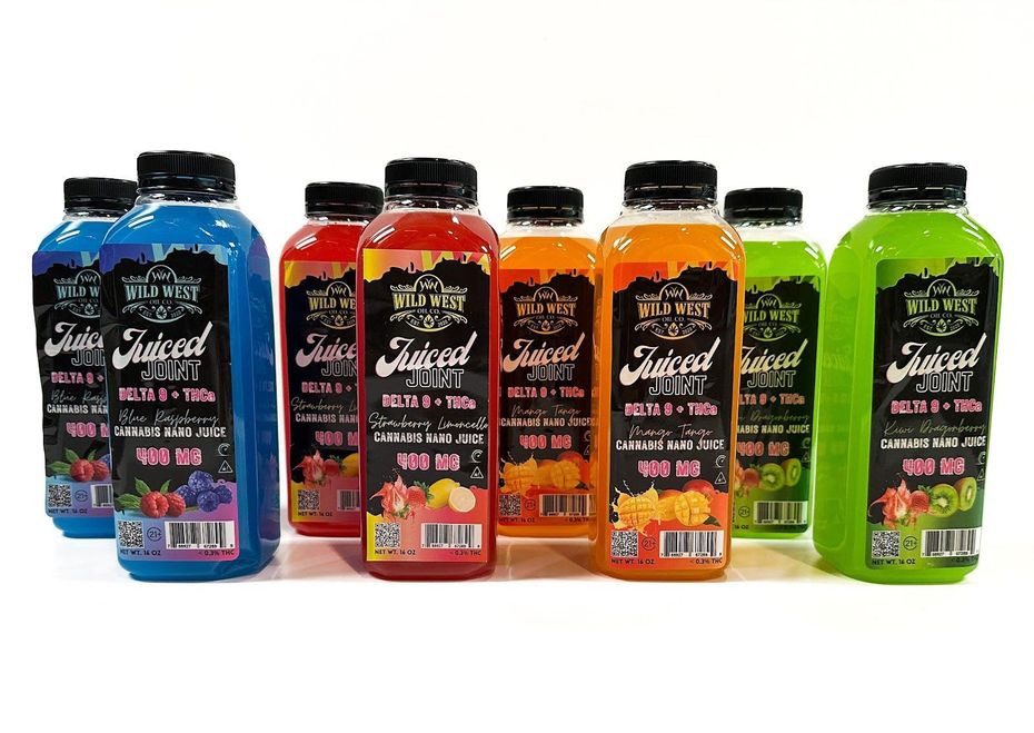 A row of eight colorful Juiced Juice drink bottles in blue, red, orange, and green on a white background.