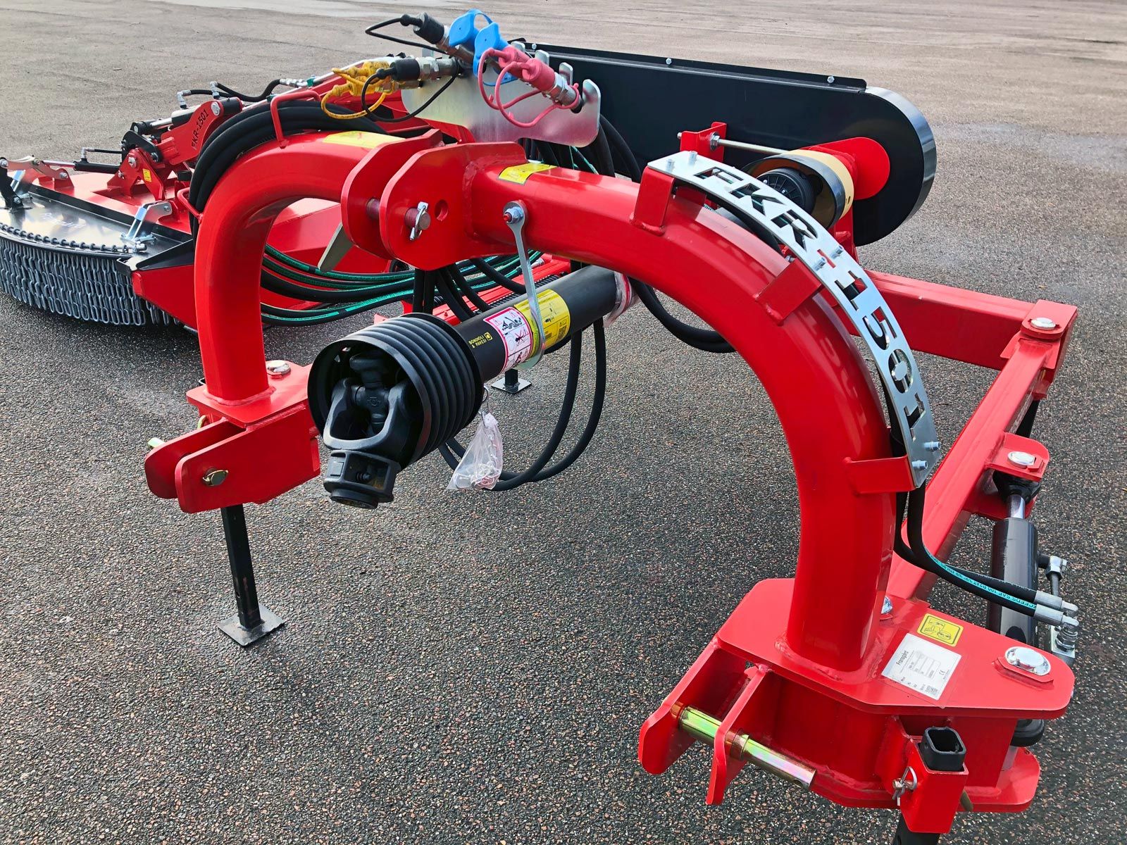 En rød kæderydder maskine er parkeret i siden af vejen.