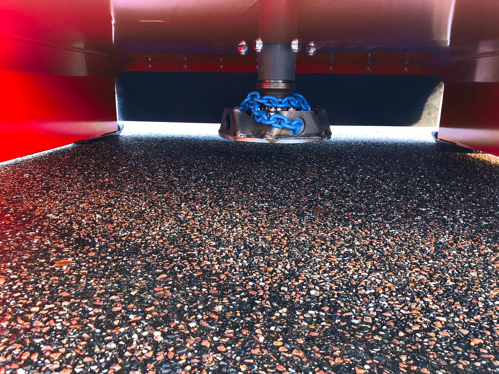 Et kædehoved på en aksel under en stor rød skærm