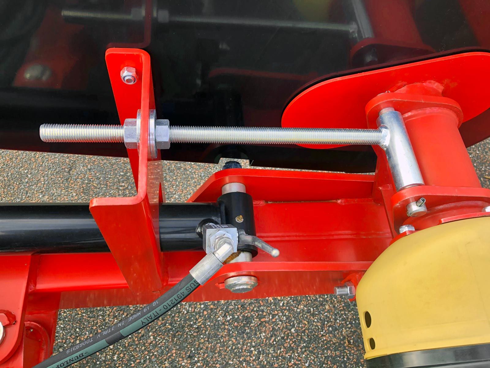 En remstrammer i blank metal monteret på rød planeringsskær